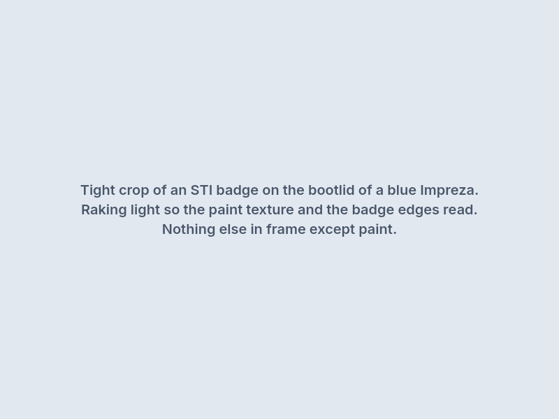 Close crop of an STI badge on a blue Impreza bootlid