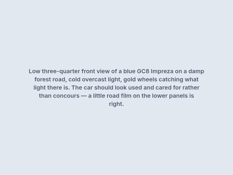 Low three-quarter view of a GC8 Impreza on a damp forest road